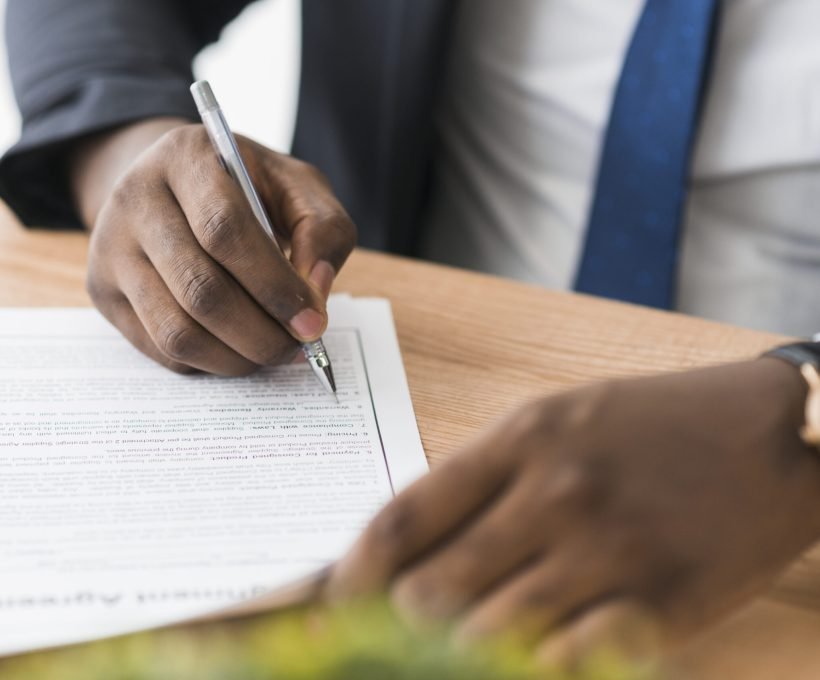 crop-ethnic-businessman-signing-papers